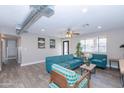 Open living area with teal sofas, wood accent tables, and an exposed duct at 7544 E Mckinley St, Scottsdale, AZ 85257