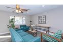 Bright living room features teal sofas, wood accents, and large windows at 7544 E Mckinley St, Scottsdale, AZ 85257