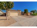 Single-story house with tan exterior and two-car garage at 16256 W Hearn Rd, Surprise, AZ 85379