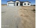 Newly built single-story home with a large driveway at 2303 S 337Th Ave, Tonopah, AZ 85354