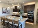 Modern kitchen with large island and stainless steel appliances at 9963 W Cora Ln, Avondale, AZ 85392