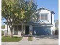 Two story house with teal garage door and manicured lawn at 17186 W Post Dr, Surprise, AZ 85388