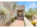 Inviting entryway with a wooden door and desert plants at 10044 E Graythorn Dr, Scottsdale, AZ 85262