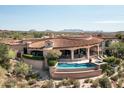 Stunning aerial view of a custom home with a large pool and mountain views at 9808 E Honey Mesquite Dr, Scottsdale, AZ 85262
