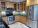 Modern kitchen featuring light wood cabinets, stainless steel appliances, and tile flooring at 3114 E Hazelwood St, Phoenix, AZ 85016