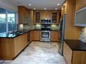 Modern kitchen with light wood cabinets, stainless steel appliances, and tile flooring at 3114 E Hazelwood St, Phoenix, AZ 85016