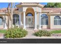 Inviting front entrance with a white door, columns, and lush landscaping at 1223 E Clearview Dr, Casa Grande, AZ 85122