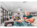 Spacious living area with sectional sofa, wood coffee table, and artistic wall mural at 8325 E Crestwood Way, Scottsdale, AZ 85250