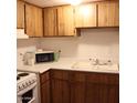 Galley kitchen with wood cabinets, microwave, and double sink at 4622 N 71St Ln, Phoenix, AZ 85033