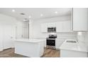 Modern kitchen with white cabinets, stainless steel appliances, and an island at 18359 W Smoketree Dr, Surprise, AZ 85387