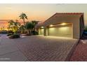Two-car garage with a well-lit driveway and desert landscaping at 13232 W Los Bancos Dr, Sun City West, AZ 85375