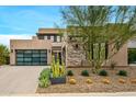 Modern home with stone and stucco exterior, attached garage, and desert landscaping at 37200 N Cave Creek Rd # 1082, Scottsdale, AZ 85262