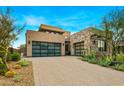 Modern home with stone and stucco exterior, attached garage, and desert landscaping at 37200 N Cave Creek Rd # 1082, Scottsdale, AZ 85262