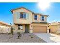 Two-story house with tan exterior, light green shutters, and a two-car garage at 7499 E Sweet Honey Ln, San Tan Valley, AZ 85143