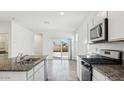 Modern kitchen with granite countertops and stainless steel appliances at 38100 W Excussare Way, Maricopa, AZ 85138