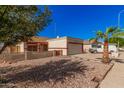 House exterior showcasing a beige stucco finish, red accents, and a two-car garage at 10014 N 66Th Ln, Glendale, AZ 85302