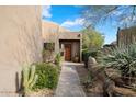 Desert landscaping surrounds this home's entrance at 9220 E Whitethorn Cir, Scottsdale, AZ 85266