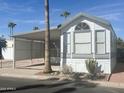 White manufactured home with gray accents and covered patio at 225 S Motherlode Dr, Apache Junction, AZ 85119