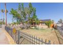 House exterior with a tree, black fence, and sidewalk at 7202 W Virginia Ave, Phoenix, AZ 85035