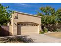 Tan stucco house with a two-car garage, desert landscaping, and a blue sky at 5505 E Mclellan Rd # 9, Mesa, AZ 85205