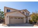 Two-story house with a tan facade, two-car garage, and landscaping at 665 W Gabrilla Ct, Casa Grande, AZ 85122