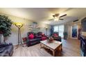 Living room with leather sofas, tile floors, and large artwork at 17447 N 99Th Dr, Sun City, AZ 85373