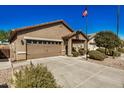 Tan house with two-car garage and landscaped yard at 22608 W Gardenia Dr, Buckeye, AZ 85326