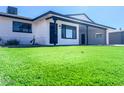 Updated mid-century home with artificial turf lawn and modern facade at 1737 N Trevor Dr, Mesa, AZ 85201