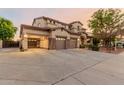 Two-story house with a three-car garage and landscaped front yard at 18657 E Pine Barrens Ave, Queen Creek, AZ 85142