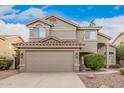 Two-story house with tan exterior, brown roof, and a two-car garage at 323 W Myrtle Dr, Chandler, AZ 85248