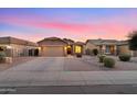 Tan house with a two-car garage and landscaped yard at 45075 W Gavilan Dr, Maricopa, AZ 85139