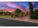 Grand home with a stone facade and lush landscaping at dusk at 2300 E Sanoque Ct, Gilbert, AZ 85298