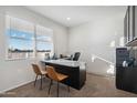 Bright home office with a large desk and chairs at 8422 W Mantle Way, Florence, AZ 85132