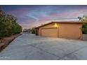 Attached garage with light-colored stucco exterior and large driveway at 985 W America St, Wickenburg, AZ 85390