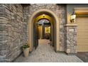 Stone arch entryway with courtyard and wrought-iron gate at 2378 N 158Th Dr, Goodyear, AZ 85395