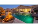 Inviting backyard with sparkling pool, fire pit, and covered patio at 3076 E La Costa Dr, Gilbert, AZ 85298