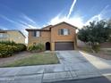 Two story home with brown exterior, two car garage, and landscaping at 2949 N Hawthorn Dr, Florence, AZ 85132