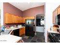 Kitchen features wood cabinets, black appliances, and a tile floor at 2423 E Pony Ln, Gilbert, AZ 85295