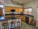 Spacious kitchen featuring wood cabinets, granite counters, and an island at 1523 E Black Diamond Dr, Gilbert, AZ 85296