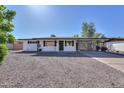 Updated Ranch home with white exterior and gravel driveway at 5521 E Adobe Rd, Mesa, AZ 85205