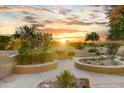 Landscaped backyard with seating and sunset view at 19562 N Wikieup Ct, Surprise, AZ 85374