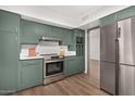 Modern kitchen with stainless steel appliances and green cabinets at 103 E Palm Ln # A, Phoenix, AZ 85004