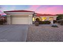 Tan one-story house with a two-car garage and nicely landscaped yard at 15340 W Black Gold Ln, Sun City West, AZ 85375