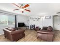 Living room with brown leather couches and wood-look floors at 2132 W Glenrosa Ave # 81D, Phoenix, AZ 85015