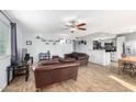 Living room with brown leather couches and a wood-look floor at 2132 W Glenrosa Ave # 81D, Phoenix, AZ 85015