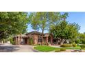 Brick home with a lush lawn and driveway, surrounded by trees at 2166 E Caroline Ln, Tempe, AZ 85284