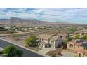 Aerial view of two-story house with pool, mountains in background at 19428 W Colter St, Litchfield Park, AZ 85340