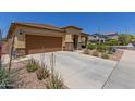 Tan house with brown garage door and stone accents at 5526 S Grenoble St, Mesa, AZ 85212