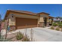 Tan house with brown garage door and stone accents at 5526 S Grenoble St, Mesa, AZ 85212