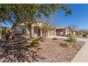 One-story house with a light brown exterior, two-car garage, and landscaped front yard at 43958 W Stonecreek Rd, Maricopa, AZ 85139